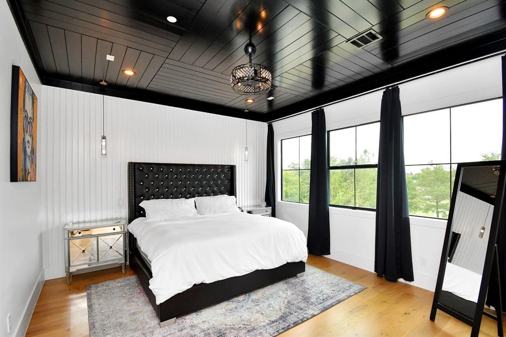 Primary bedroom with black shiplap ceiling
